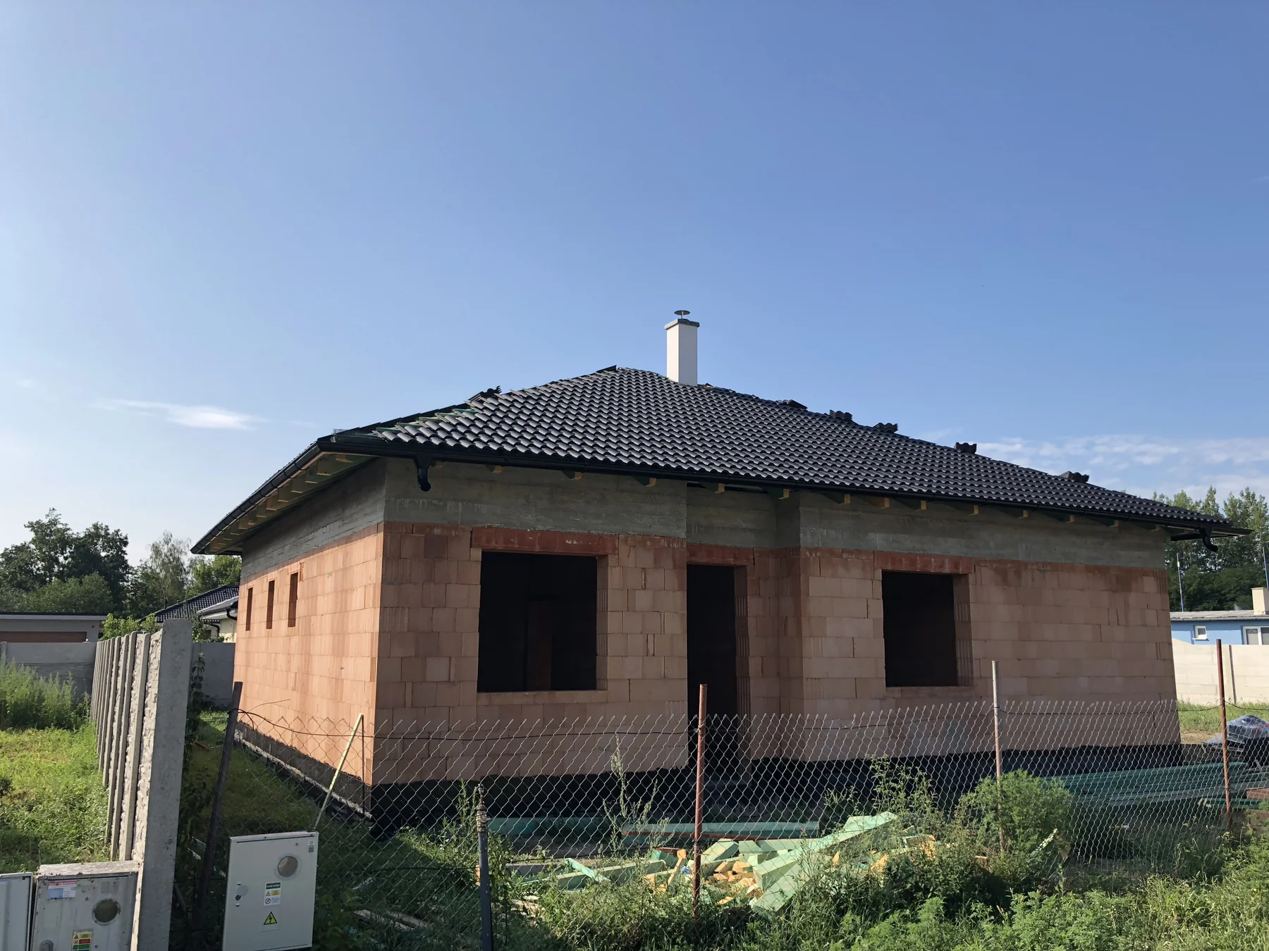 Tehlová hrubá stavba rodinného domu s dokončenou strechou