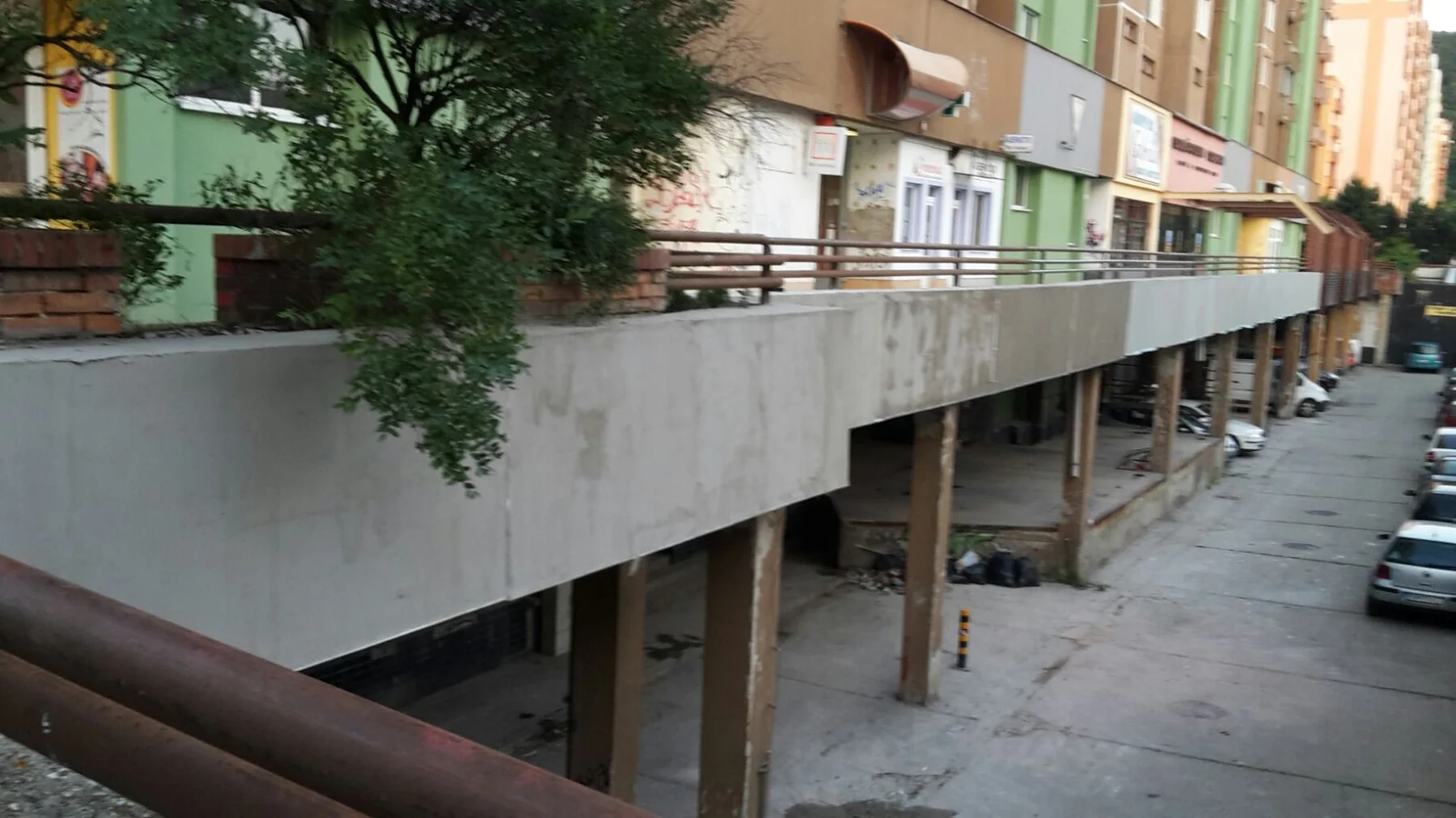 Dlhý vonkajší balkón so zábradlím a fasádou pod jeho hranou